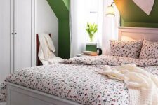 24 a bright attic bedroom with green walls, white furniture, floral bedding, lamps and a heart over the bed