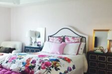 28 a glam bedroom with an upholstered bed and floral bedding, a fuchsia upholstered bench, black dressers and a chair