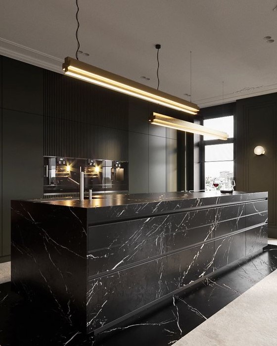 an exquisite black kitchen with plain cabinets and an oversized black marble kitchen island plus touches of gold