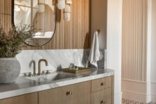 30 a contemporary bathroom with an arched niche clad with wood, a curved mirror, a floating vanity and cool pendant lamps