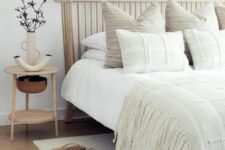 30 a neutral bedroom with a curved wooden slat headboard and textural and woven bedding, pieces of wood on the wall and a nightstand with unique lamps