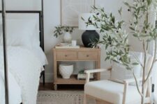 31 a chunky knit blanket, a printed rug, a wooden nightstand, a basket and a metal frame of the bed bring much texture to the bedroom