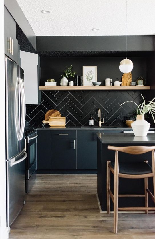 a contemporary moody kitchen with sleek black cabinetry, a black tile backsplash, a wooden shelf and wooden stools and pendant lamps