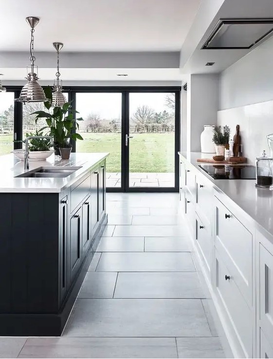 a contemporary kitchen with white cabinets and a black kitchen island plus the same countertops for both