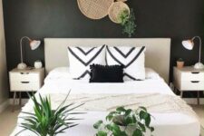 37 a stylish boho bedroom with a black accent wall, a neutral bed, printed pillows and a printed rug, potted greenery