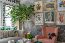 38 a bold maximalist living room with printed wallpaper, a grey sofa, a pink chair, an ottoman and a bright gallery wall