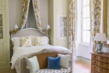 38 an exquisite Provence bedroom with tan cabinets, a grey bed with a refined design, floral textiles, a loveseat with pillows and lamps