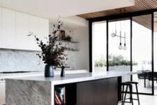 39 a gorgeous contemporary ktichen with sleek white cabinets, a grey stone backsplash and countertops, a black kitchen island and a layered ceiling