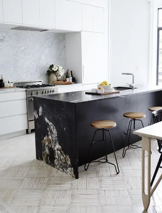 a modern white kitchen and a black kitchen island, a marble backsplash and countertop to tie them up