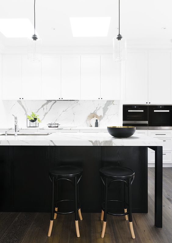 a refined contemporary kitchen with white shaker style cabinets, a black kitchen island, a white marble backsplash and countertops