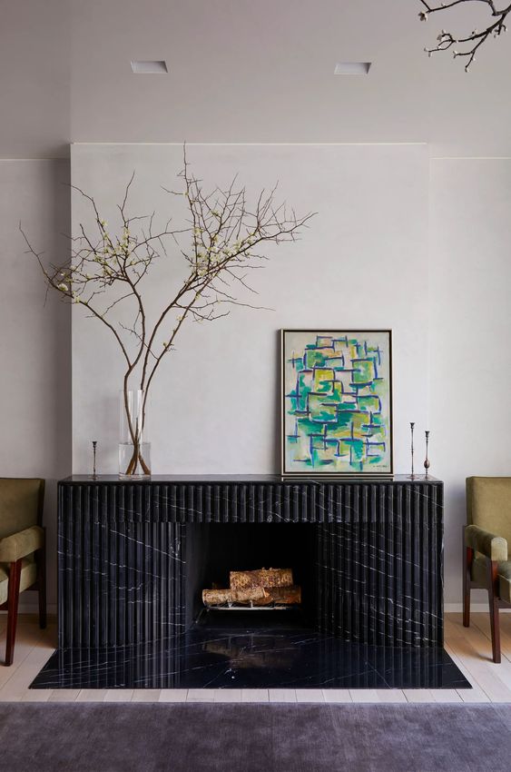a beautiful black fireplace with a fluted marble surround is a chic and stylish idea for a living room