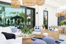 78 a coastal living room with a white sofa, woven chairs, a rattan table, a bold blue rug and blue poufs