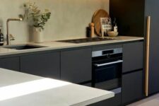 a beautiful contemporary kitchen with matte black cabinets and a fluted hood, a fluted lower cabinet and built-in lights