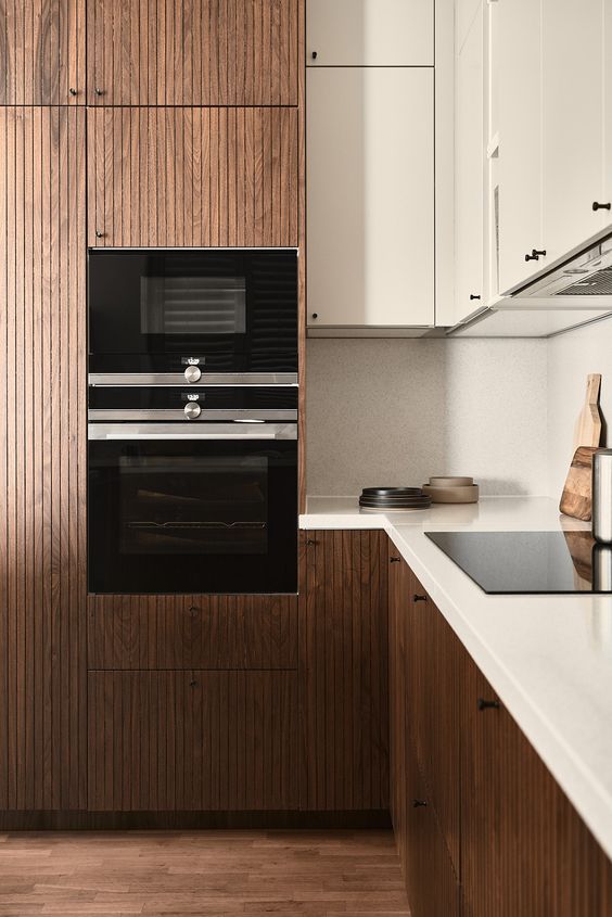 a beautiful rich-stained ribbed kitchen with creamy upper ones and matching countertops plus a backsplash looks chic