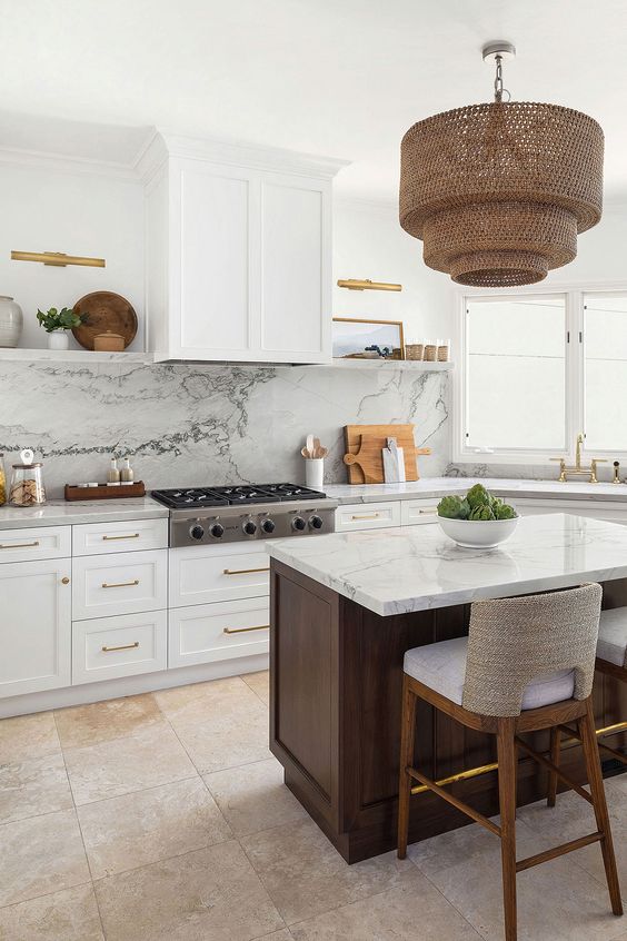 a beautiful white kitchen with shaker cabinets, a white quartz backsplash and countertops, a dark-stained kitchen island and a woven pendant lamp
