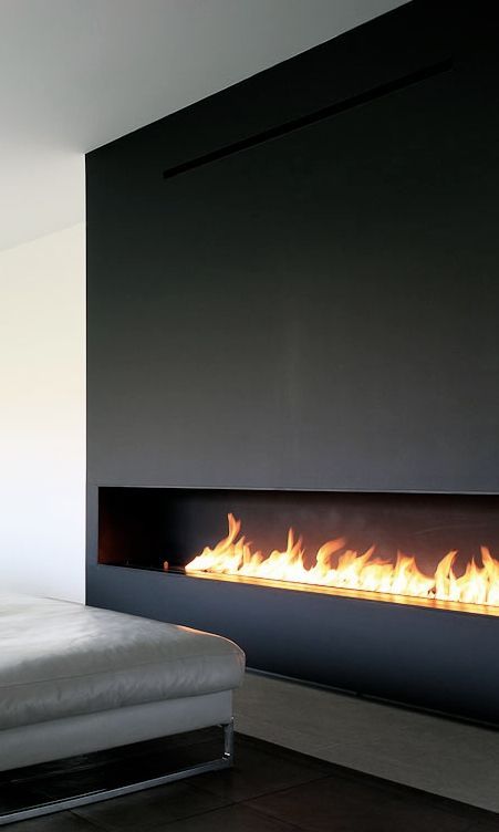 a black minimalist fireplace, a grey leather daybed are a chic and bold combo for a minimalist space