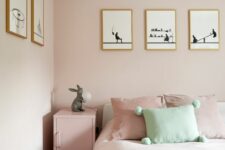 a blush bedroom with a bed with blush and green pillows, a pink nightstand and a gallery wall in black and white