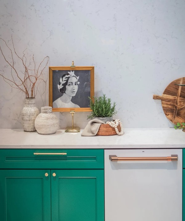 a bold emerald kitchen with shaker cabinets, a white quartz backsplash and matching countertops, some lovely decor
