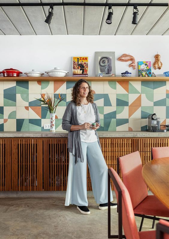 a colorful kitchen with fluted stained cabinets, a concrete countertop, a colorful tile backsplash and an open shelf for displaying