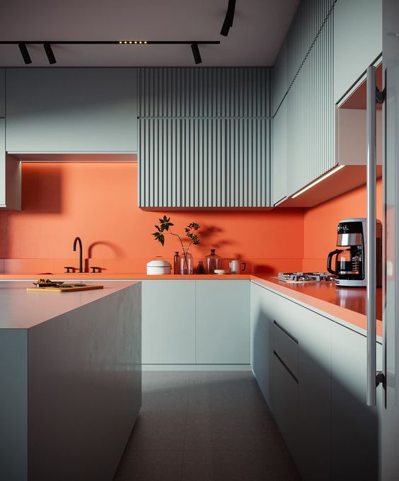 a colorful kitchen with slate blue plain and ribbed cabinets, an orange backsplash and countertops plus black fixtures
