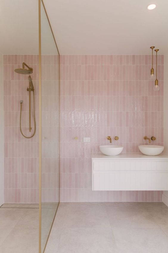 a contemporary bathroom with pink skinny tiles, neutral large scale ones, brass fixtures and a white floating vanity