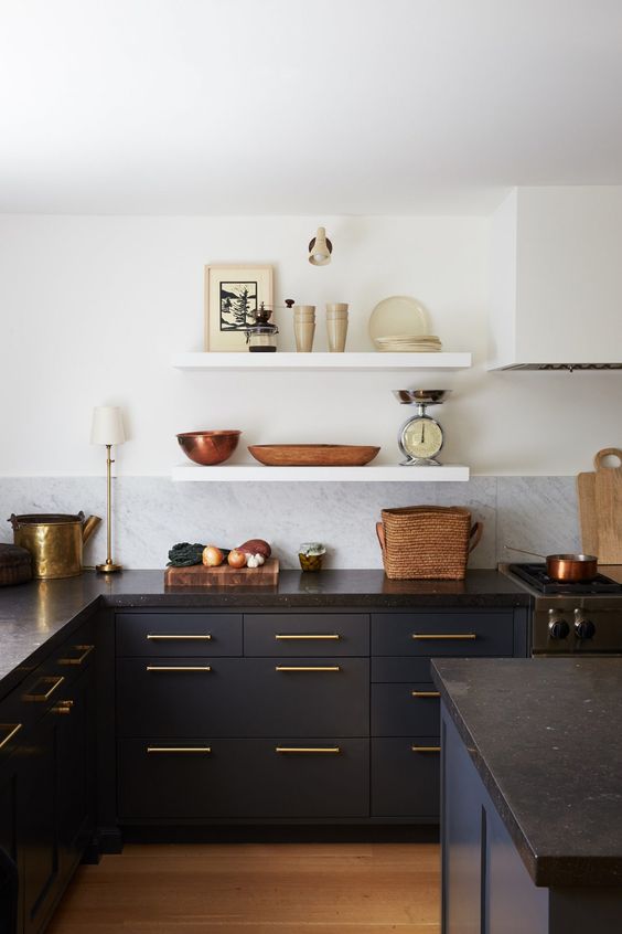 a contrasting navy and white kitchen with a white marble tile backsplash, black countertops and open shelves