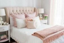 a cute and sweet feminine bedroom with grey walls, a neutral bed with pink ruffled bedding, a pink rug and white nightstands