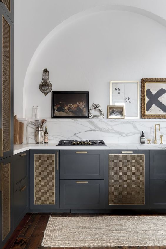 a dark grey kitchen with shaker cabinets, rattan doors, a white quartz backsplash and countertops, a ledge with some lovely decor