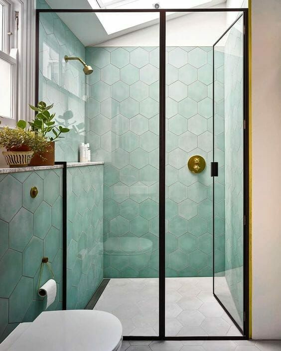 ديكورات حمامات حديثة A-delicate-bathroom-with-green-hexagon-tiles-a-skylight-black-frames-and-potted-plants-white-appliances