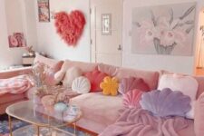 a feminine living room with a pink sofa, pastel pillows and blankets, a fluffy pink heart and a tiered glass table