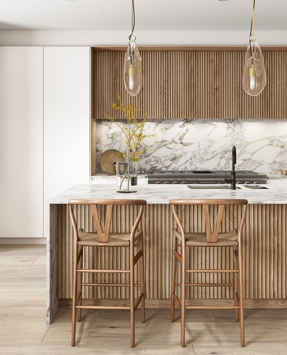 a gorgeous plain white and stained ribbed kitchen with a white marble backsplash and countertops plus a matching kitchen island