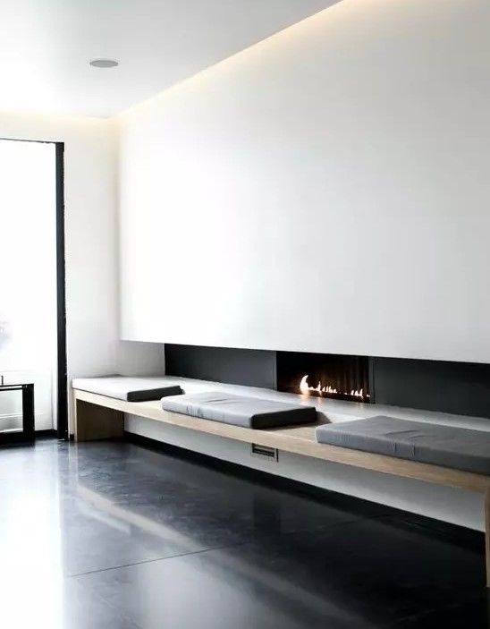 a minimalist ethanol fireplace, a comfy bench next to it bring a touch of luxury to the interior