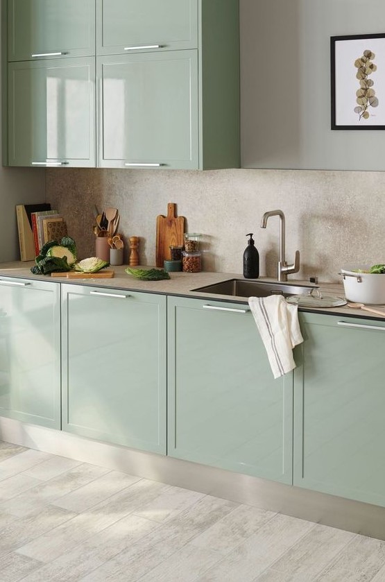 a minimalist kitchen in mint green, with sleek cabinets, a beadboard countertop and a plywood backsplash