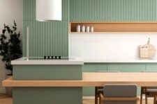 a minimalist kitchen with ribbed and plain green cabinets, an niche shelf, a large kitchen island and a round hood