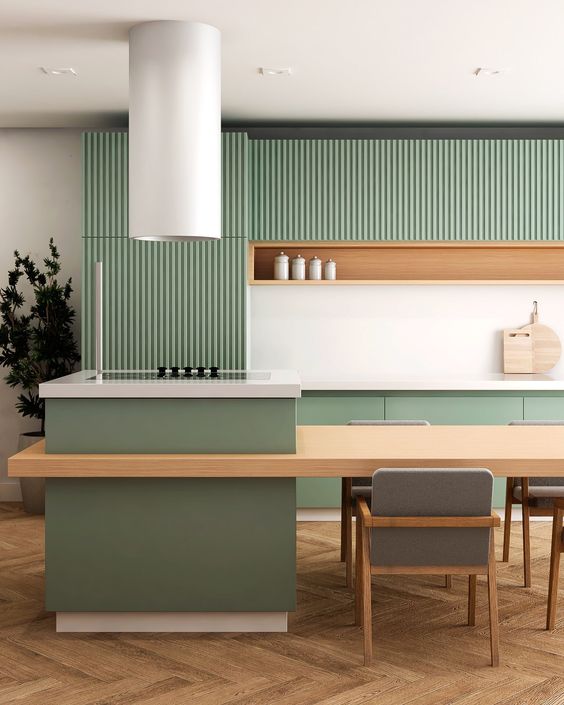 a minimalist kitchen with ribbed and plain green cabinets, an niche shelf, a large kitchen island and a round hood