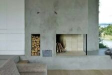 a minimalist living room with a concrete fireplace, a niche for firewood storage and simple furniture