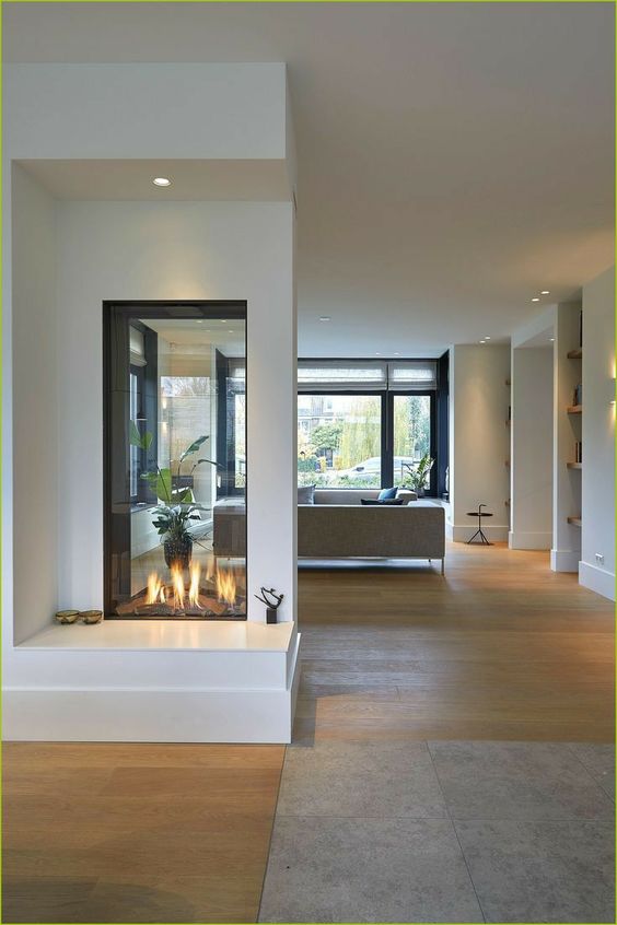 a minimalist white double sided fireplace with an additional seat by its side is a cool idea to enjoy fire from all sides