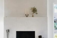 a minimalist white fireplace with decor on the mantel and next to it is a spectacular decor feature for any minimal space
