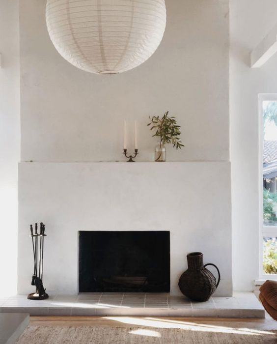 a minimalist white fireplace with decor on the mantel and next to it is a spectacular decor feature for any minimal space