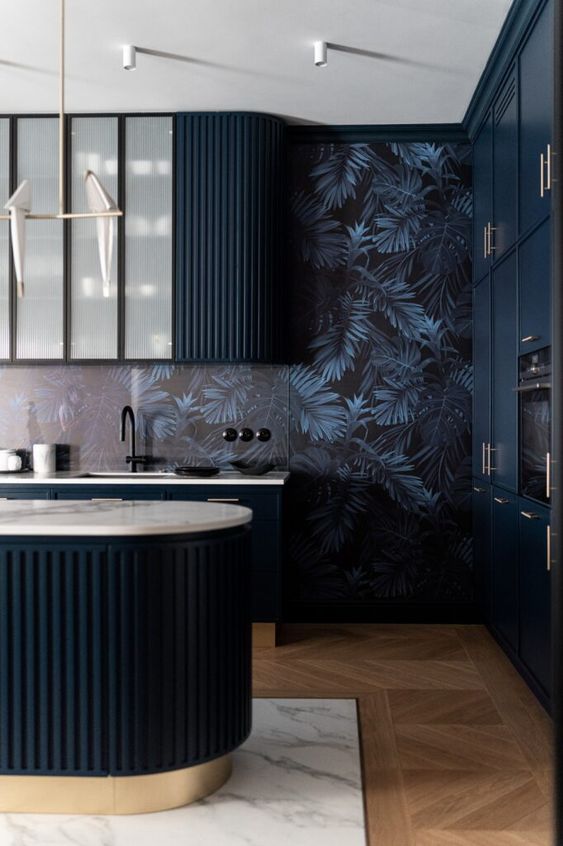 a moody and elegant kitchen with midnight blue curved cabinets and a matching kitchen island, dark wallpaper on the walls and black fixtures