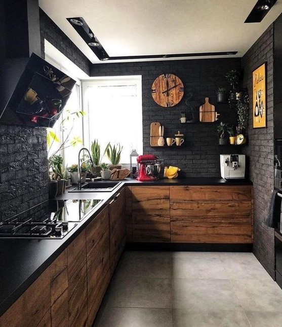 a moody black kitchen with faux brik walls, black countertops plus MDF cabinets and touches of yellow
