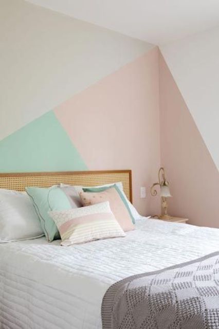 a simple bedroom with a geometric accent on a wall