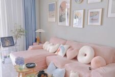 a pastel living room with grey walls, a pink sectional, blue curtains, a pink and blue rug and a stained coffee table