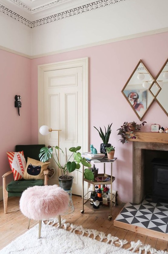 a pink living room with chic modern furniture, a fireplace clad with tiles, lots of potted plants and printed pillows