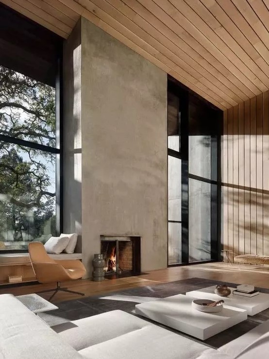 a refined minimalist living room with a concrete fireplace, neutral furniture, wooden walls and ceiling plus glazed walls