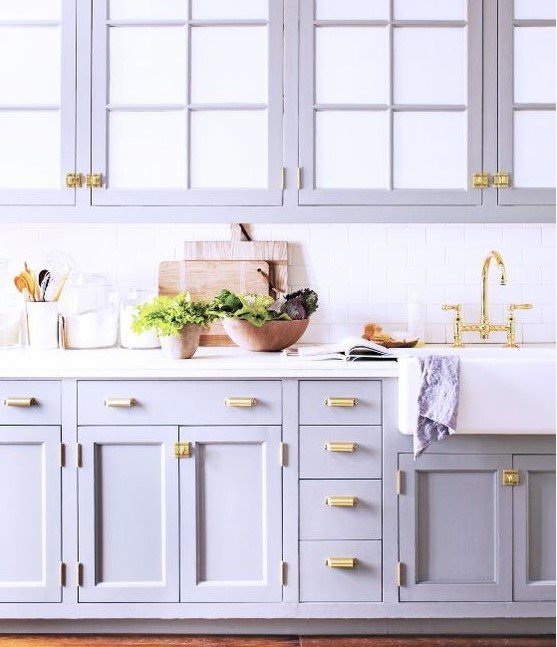 a romantic lilac kitchen with a white subway tile backsplash and a white countertop plus gold touches