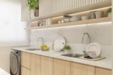a small neutral kitchen with light-stained and white ridged cabinets, a long open shelf and built-in lights plus greenery