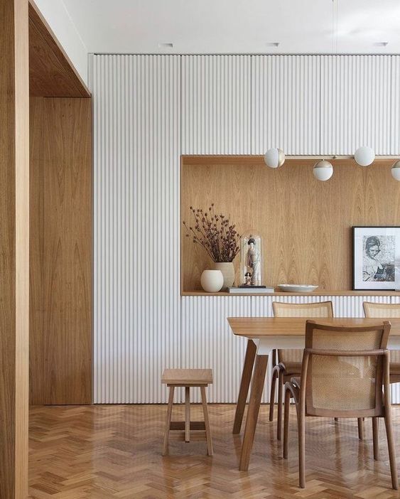 a small white built-in kitchen with ribbed cabinets, a niche as a countertop clad with plywood and a dining zone right here