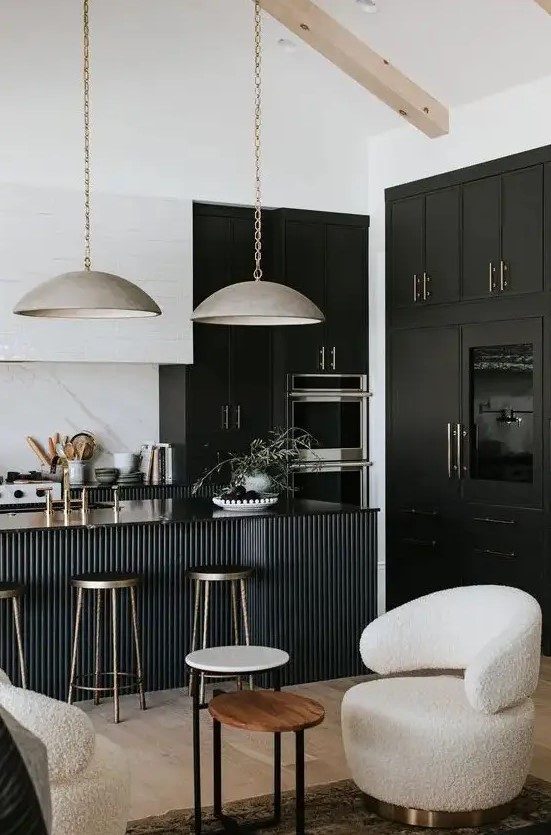a sophisticated black and white kitchen with black and white cabinets, a black fluted kitchen island and gorgeous metal lamps hanging on chain