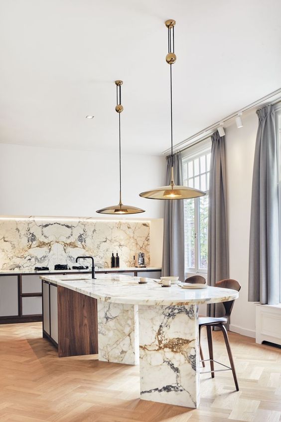 a sophisticated contemporary kitchen with sleek white cabinets, a curved kitchen island made of wood and marble